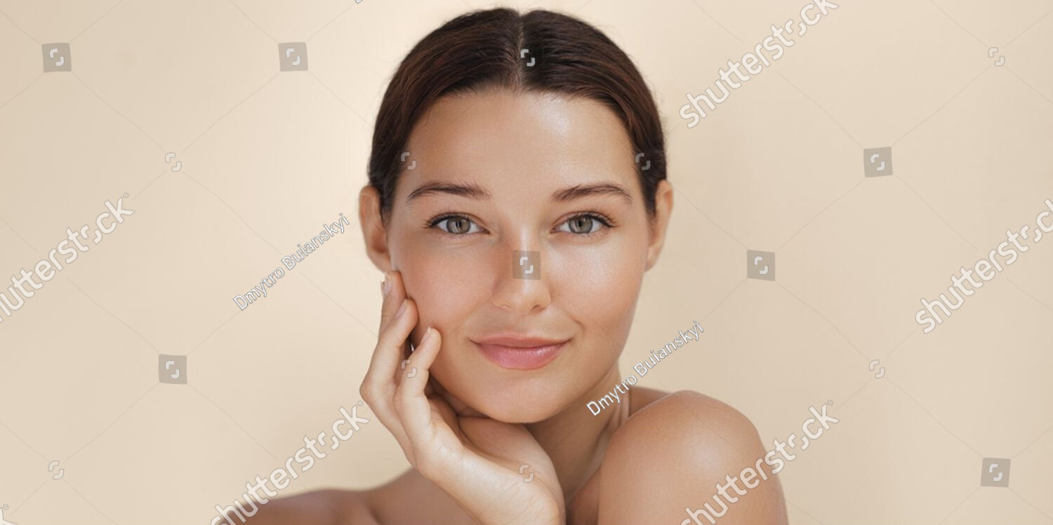 Stock photo close up portrait of a woman with radiant glowing skin gently touching her face her flawless 2562279807